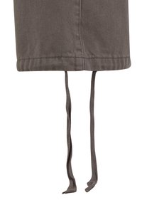 Jupe en mélange de coton gris à coupe droite, avec un ourlet cousu et deux liens en tissu ajustables en bas. Détails de surface texturée visibles.