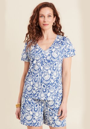 Tenue à motifs floraux bleus et blancs avec un col en V, des manches courtes et un short ; fabriquée en tissu léger avec une finition texturée.