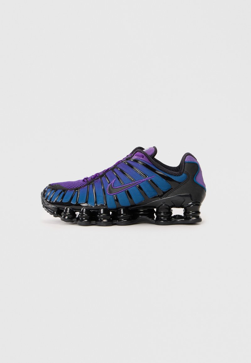 Nike sneakers with a purple and blue mesh upper featuring black accents. Unique wavy sole design with visible cushioning elements.
