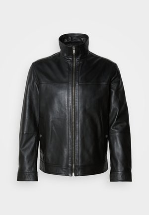 Casaco de couro preto com gola alta, fechamento frontal com zíper, bolsos laterais e textura suave. Apresenta costuras e detalhes de hardware discretos.