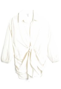 White blouse with a tie front, collared neckline, and long sleeves with elastic cuffs. Soft fabric, featuring a knotted detail at the waist.