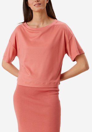 Kortekorte mouw, gecropte top van zacht koraalkleurige stof met een ronde hals en een relaxte pasvorm, gecombineerd met een bijpassende strakke rok.