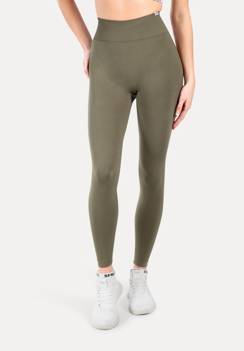 Högmidjade olivgröna leggings tillverkade av ett mjukt, elastiskt tyg med subtil ribbad textur. Har en säker, elastisk midjeresår.
