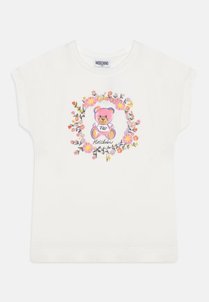 Camiseta blanca de manga corta con un gráfico colorido de un oso rodeado de patrones florales y el texto "Moschino" debajo.