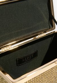 Ports pentru clutch metalic auriu cu un model texturat. Interiorul este căptușit cu țesătură neagră și are o etichetă. Închidere cu clemă în partea de sus.