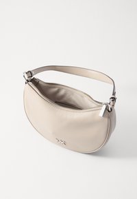 Beige lædertaske med en buet form, lynlås i toppen og en enkelt rem. Har et sølvlogo på forsiden. Glat tekstur.