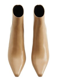 Botines en tono tostado, fabricados en cuero suave, con punta afilada, un diseño estilizado y una cremallera lateral para facilitar el uso.