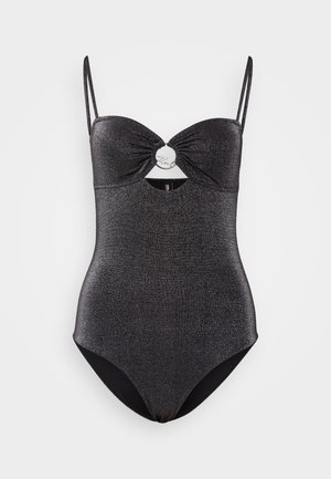 Maillot de bain noir une pièce avec un tissu scintillant, détail découpé à la taille et fines bretelles ajustables. Présente un accent circulaire au centre.