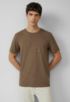 Bruine katoenen t-shirt met een ronde hals en korte mouwen, voorzien van een vierkante zak op de linker borst met een subtiele logopatch.