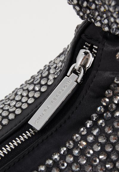 Μαύρη υφασμάτινη τσάντα καλυμμένη με ασημένιες ρινοκέρες, με μεταλλικό φερμουάρ και ετικέτα που γράφει "Chiara Ferragni."