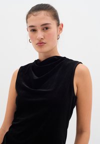 MustHave mustrisideta top, mis on valmistatud pehmest kangast, drapeeritud kaelusega, sil 소재et with smooth texture and fitted silhouette.