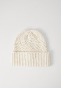 Gorro de punto color crema con un borde ribeteado doblado y un patrón de zigzag en el cuerpo principal.