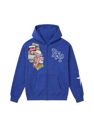 Sudadera con capucha azul con cremallera, bolsillos frontales, logotipo "RXP" en el pecho, estrella en la manga izquierda y múltiples parches vintage coloridos con temática de gasolina en el lado derecho.
