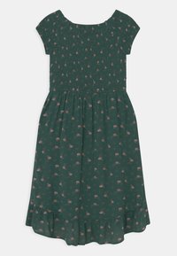 Vihreä kukallinen mekko lyhyillä hihoilla, lommoitetulla bodysuunnittelulla ja levenevällä hameella. Sisältää pieniä vaaleanpunaisia kukkia ja röyhelöreunan yksityiskohtana.