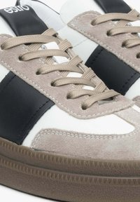 Białe, beżowe i czarne sneakersy z zamszowej i skórzanej cholewki, płaskimi sznurowadłami, kontrastowym paskiem i teksturowaną gumową podeszwą.