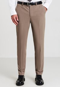 Pantaloni beige su misura con una finitura in tessuto liscia, davanti piatto, tasche frontali e una vestibilità slim, abbinati a scarpe in pelle nere.