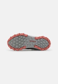 Semelle de chaussure robuste grise et rose avec des motifs de bande de roulement profonds et un logo central Columbia sur fond blanc.
