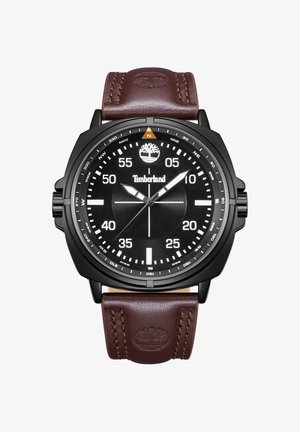 Okrągły czarny zegarek Timberland z białymi cyframi, oznaczeniami kompasu, trzema wskazówkami oraz brązowym skórzanym paskiem z wytłoczonym logo drzewa.