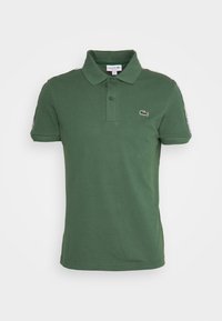 Green short-sleeve Lacoste polo shirt with collar, two-button placket, and small embroidered crocodile logo on chest.