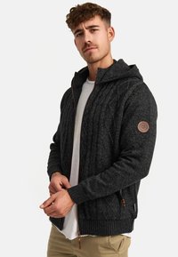 Męska ciemnoszara dziana bluza z kapturem zapinana na zamek, z wzorem w warkocze, ściągaczami na rękawach i skórzaną naszywką z logo na rękawie.