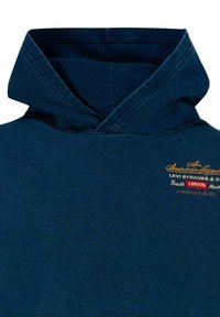 Felpa blu scuro con colletto ripiegato, caratterizzata da dettagli in tessuto ricamati in oro e rosso. Realizzata in un morbido tessuto testurizzato.