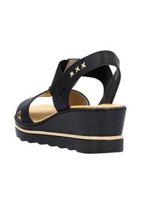 Sandalo a zeppa nera con punta aperta e ritagli laterali. Presenta dettagli cuciti e una suola texture per aderenza e comfort.
