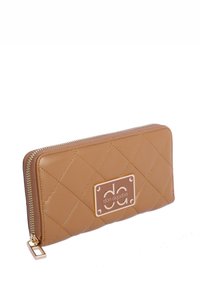 Cartera acolchada beige con detalle de placa de logo dorada, cierre de cremallera y acentos en hardware dorado. Textura suave y forma rectangular.