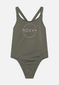 Olivgrön baddräkt med justerbara korsade band, med en rosa "ROXY"-logotyp omgiven av en cirkulär design på framsidan.