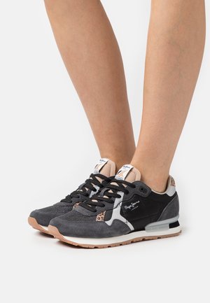 Schwarz-graue Sneaker aus Wildleder und Mesh mit Leopardenmuster-Akzent und schwarzen Schnürsenkeln vor weißem Hintergrund.