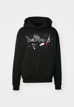Hoodie noir avec un graphique avant affichant le nom "CARLO COLUCCI" en blanc, entouré de taches de peinture colorées. Texture douce, coupe décontractée.