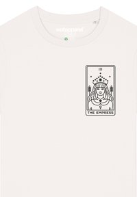 Lichtbeige katoenen t-shirt met een zwart-ink grafiek van een tarotkaart met het label "DE KEIZERIN", waarop een figuur met een kroon en sterren is afgebeeld.