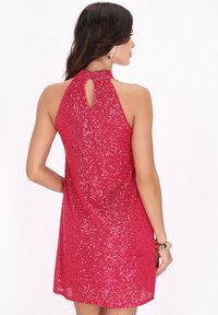 Rochie cu gât halter în roz vibrant, decorată cu paiete. Are un decolteu în formă de inel și o croială lejeră, adaptându-se la diverse forme ale corpului.