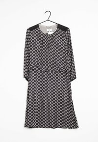 Musta mekko pitkillä hihoilla, jossa on valkoisia ja vaaleanpunaisia kuusikulmioita. Siinä on pyöreä pääntie ja vyötärösidonta. Silkkinen kangas, joka roikkuu koukusta.