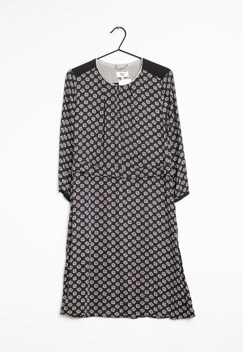 Musta mekko pitkillä hihoilla, jossa on valkoisia ja vaaleanpunaisia kuusikulmioita. Siinä on pyöreä pääntie ja vyötärösidonta. Silkkinen kangas, joka roikkuu koukusta.