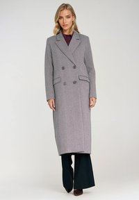 Dwurzędowy płaszcz w wzór w pepitkę, szaro-biała tkanina, dopasowany krój, długi fason, z dwoma przednimi kieszeniami i akcentami guzików.