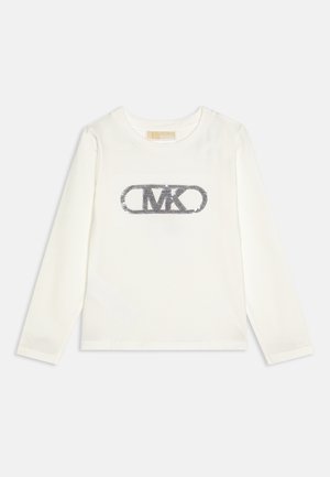 Hvid skjorte med lange ærmer og rund halsudskæring med et sort pyntet "MK" logo i midten af brystet.