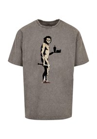 Graues Baumwoll-T-Shirt mit einer gedruckten Illustration eines Höhlenmenschen, der einen Knüppel haltet, umgeben von einfachen Umrissen von Fast Food Artikeln im Hintergrund.
