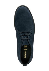 Chaussures Geox en daim marine foncé avec une finition lisse, présentant un design à lacets, un bout rond et une semelle en caoutchouc noire, étiquetées pour un confort ultra.