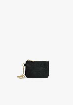 Petit porte-monnaie en cuir noir texturé avec fermeture éclair dorée et chaînette porte-clés dorée attachée sur fond blanc.