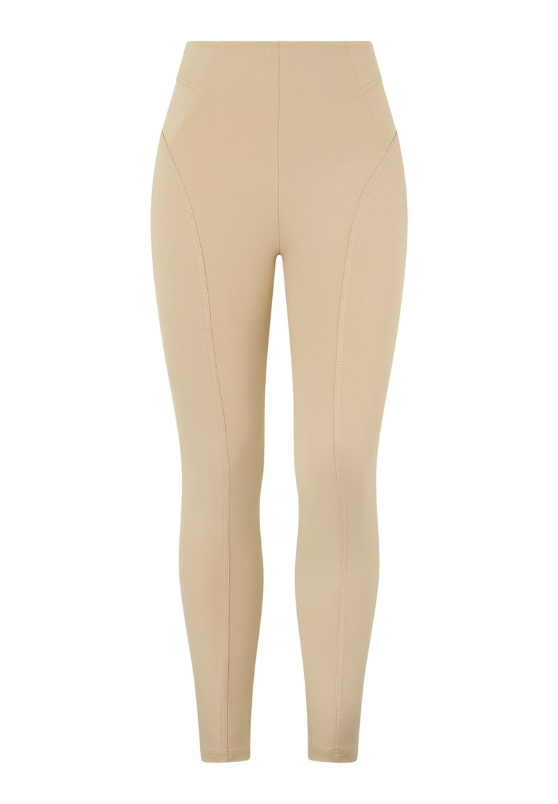 Leggings beige a vita alta con una texture liscia, caratterizzati da dettagli di cuciture diagonali e un design aderente. Nessuna tasca visibile.