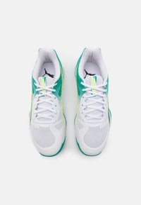 Baskets de sport blanches avec des accents turquoise et jaunes, dotées d'une tige en mesh, d'un bout arrondi et d'un système de laçage. Logos visibles sur la languette.