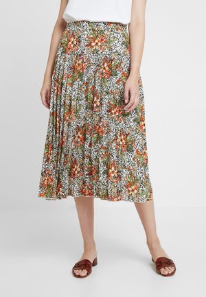 Bloemige midi-rok met zwart-wit luipaardprint, versierd met oranje bloemen, geplooide ontwerp en elastische tailleband. Gecombineerd met bruine sandalen.