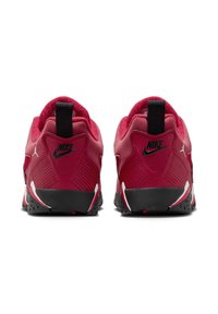 Scarpe sportive rosse con tessuto testurizzato, dettagli neri e una suola a fantasia. Presentano un prominente tab sul tallone e il marchio Nike.