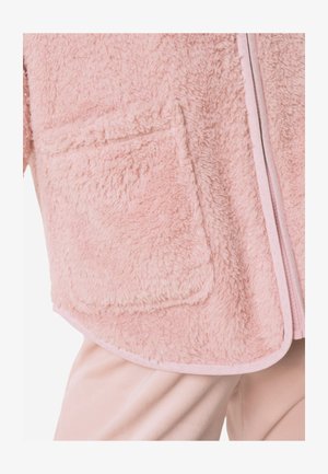 Pull-over zippé rose et pelucheux avec une texture douce, doté d'une poche avant et d'une bordure contrastante le long de la fermeture éclair.