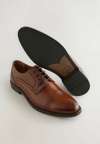 Barna bőr öltönycipő sima felülettel, fűzős kialakítással, körömhegy részletezéssel és fekete gumitalppal, amelynek bordázott mintája van.