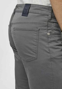 Graue Baumwollmischhose mit einer Gesäßtasche, die über dezente Steppnähte verfügt, und einem vertikalen Logoband am Bund.