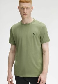 T-shirt verde a girocollo realizzato in cotone, con maniche corte e un piccolo logo ricamato nero sul petto. Texture liscia.