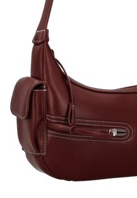 Bordowa skórzana torebka z białym przeszyciem, zaokrąglonym kształtem, przednią kieszenią na klapie oraz zamykaną na zamek komorą z boku.