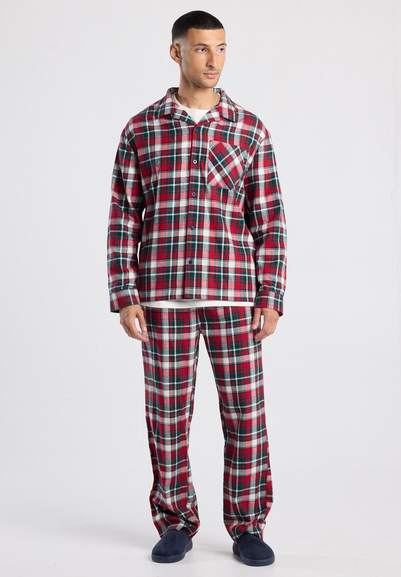 Rood en groen geruit pyjama-set van zachte stof, met een knoopsluiting shirt met een borstzak en bijpassende wijde broek.