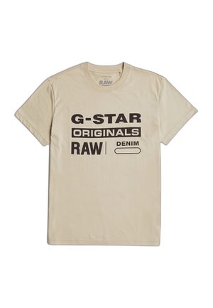 T-shirt beige en coton avec un texte noir audacieux : "G-STAR RAW ORIGINALS DENIM." Col rond classique et manches courtes. Texture du tissu uni.